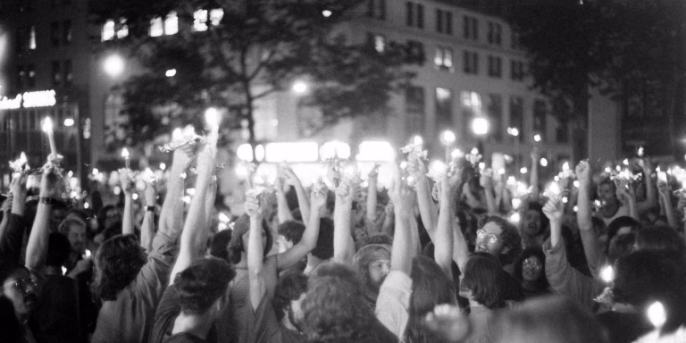 Crowd gathered outside the Stonewall Inn in New York City during the 1969 Stonewall Uprising, a pivotal moment in queer history and LGBTQIA+ resilience.